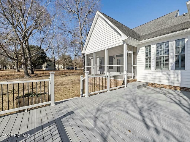 deck featuring a lawn and a sunroom