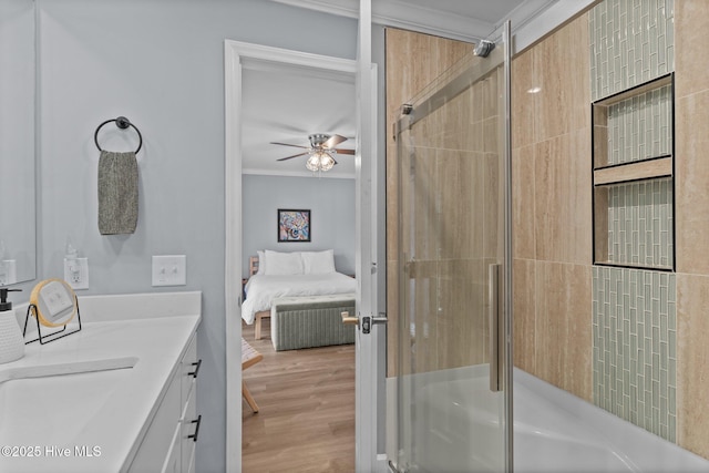 bathroom with hardwood / wood-style flooring, ceiling fan, an enclosed shower, vanity, and ornamental molding