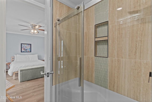 bathroom featuring ceiling fan, a shower with shower door, ornamental molding, and wood-type flooring