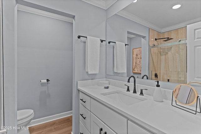 bathroom featuring a shower with door, hardwood / wood-style floors, vanity, ornamental molding, and toilet