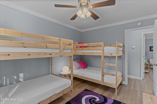 bedroom featuring crown molding, wood-type flooring, and ceiling fan