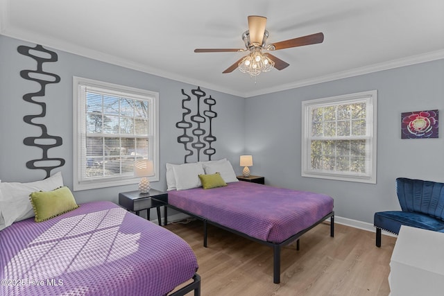 bedroom featuring multiple windows, crown molding, ceiling fan, and light hardwood / wood-style flooring