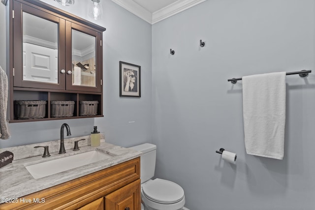 bathroom with crown molding, vanity, and toilet