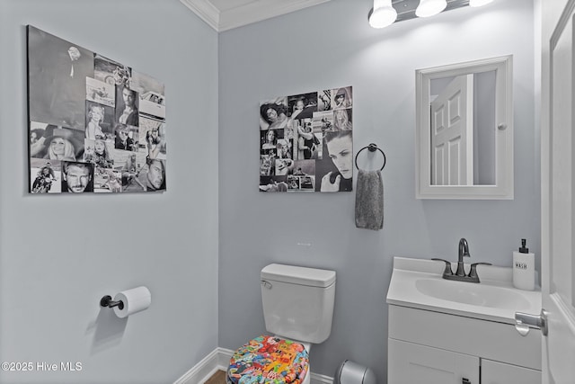 bathroom with vanity, crown molding, and toilet