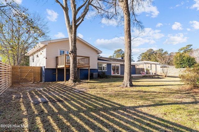 back of house featuring a wooden deck, central AC, and a lawn