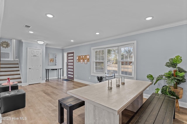 dining space featuring crown molding and light hardwood / wood-style floors