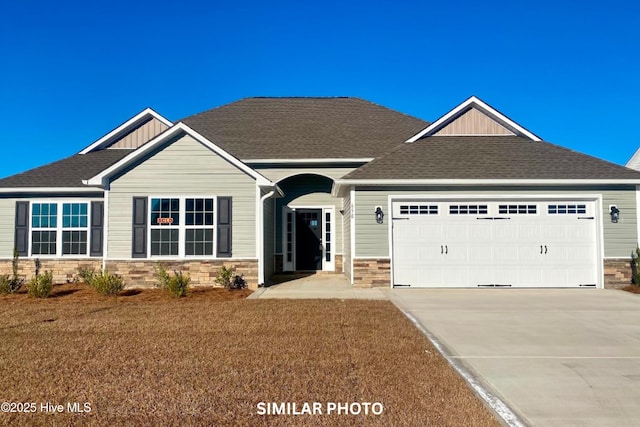 craftsman inspired home with a garage and a front lawn