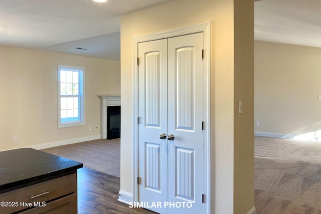 hallway with dark colored carpet