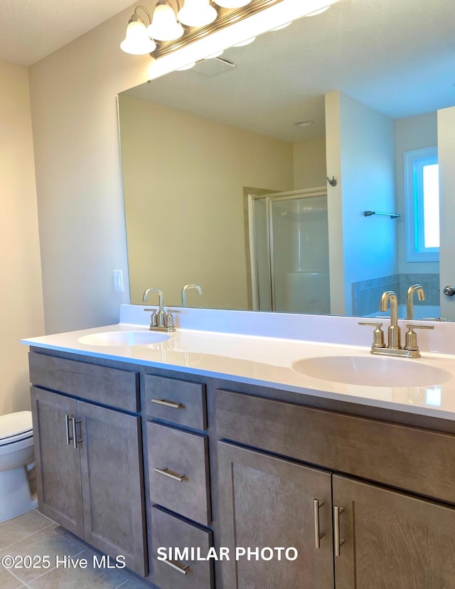 bathroom with tile patterned flooring, vanity, an enclosed shower, and toilet