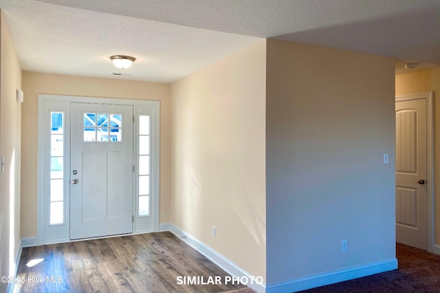 foyer entrance featuring a textured ceiling and hardwood / wood-style flooring