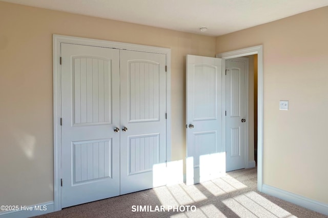 unfurnished bedroom with light carpet and a closet