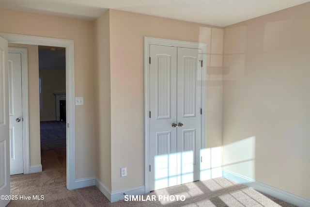 unfurnished bedroom with light carpet and a closet