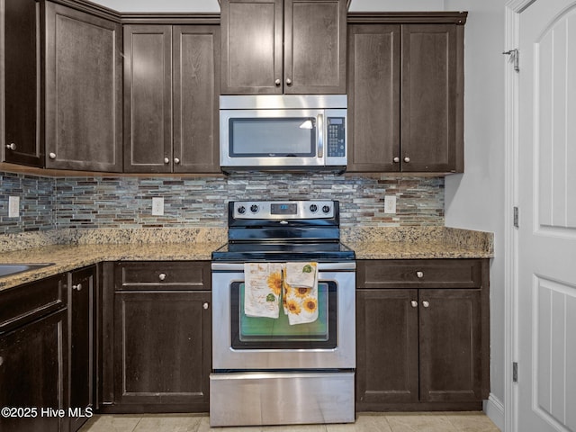 kitchen with light stone counters, appliances with stainless steel finishes, and tasteful backsplash