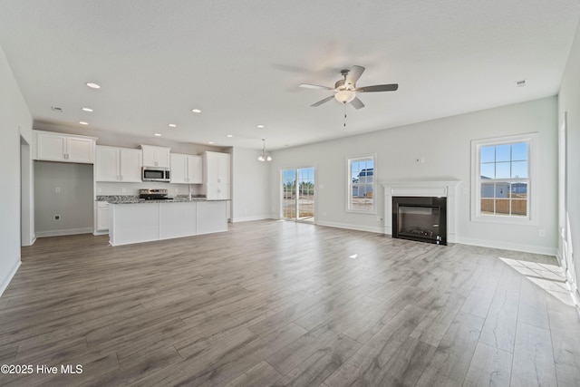 unfurnished living room featuring ceiling fan and light wood-type flooring