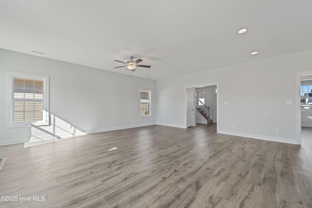 unfurnished living room with ceiling fan, light hardwood / wood-style flooring, and a healthy amount of sunlight