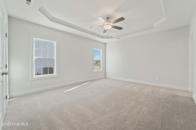 carpeted spare room featuring ceiling fan and a tray ceiling