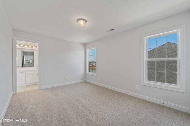 carpeted empty room featuring a textured ceiling