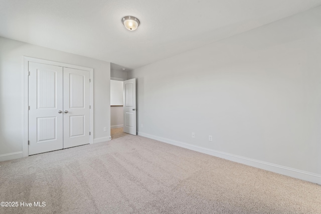 unfurnished bedroom featuring a closet and light carpet