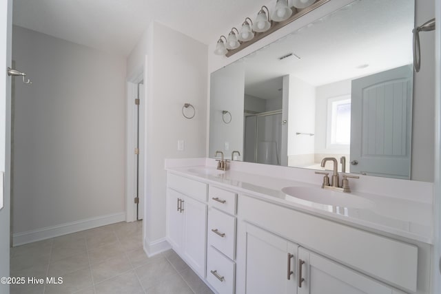 bathroom with vanity, a shower with door, and tile patterned flooring