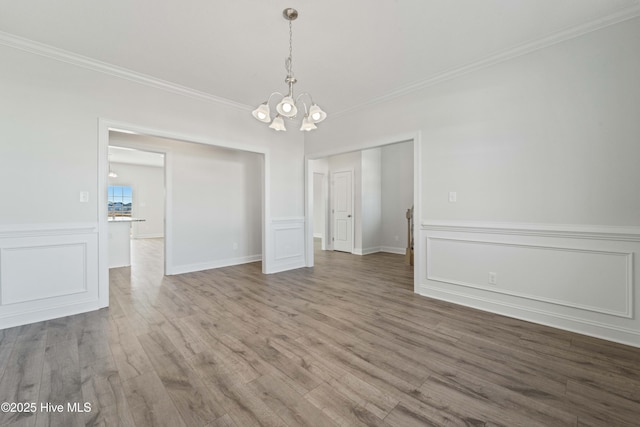 interior space featuring an inviting chandelier, hardwood / wood-style flooring, and ornamental molding