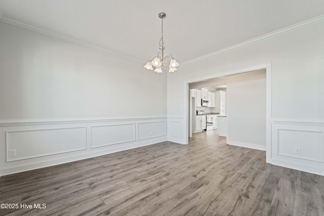 unfurnished dining area with crown molding, a chandelier, and light hardwood / wood-style floors