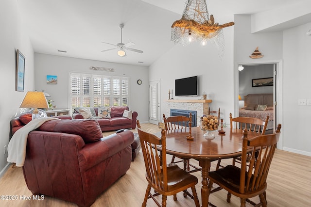 living room with ceiling fan, vaulted ceiling, and light hardwood / wood-style flooring