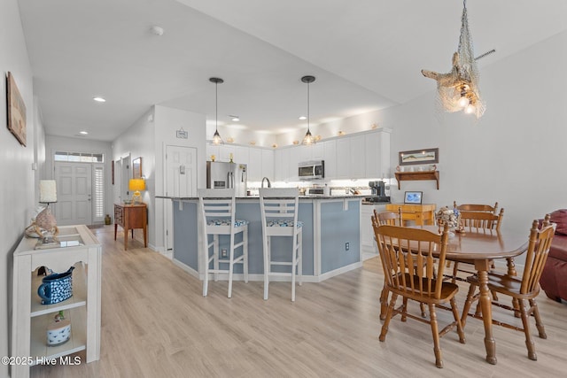 dining room with sink and light hardwood / wood-style flooring