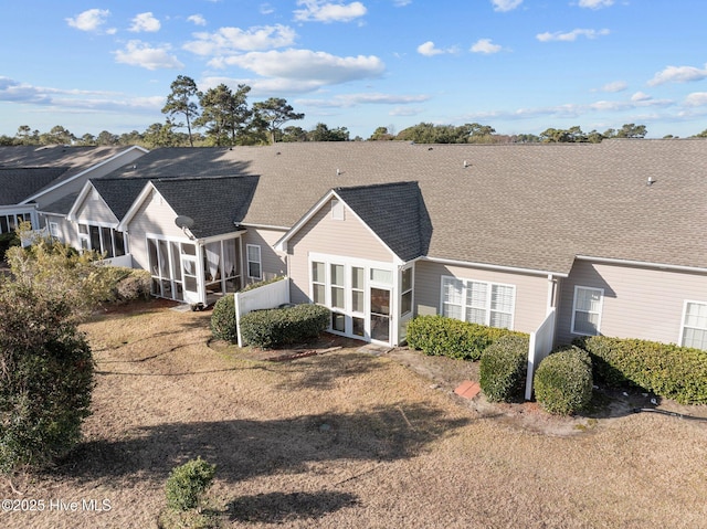 rear view of property with a lawn and a sunroom