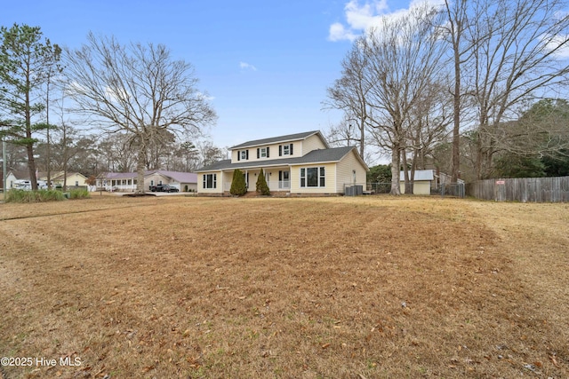 view of front of property with central AC and a front lawn