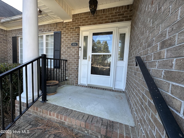 entrance to property featuring brick siding