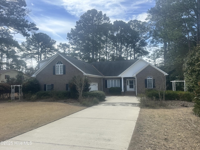 view of front of home featuring a garage, driveway, and brick siding