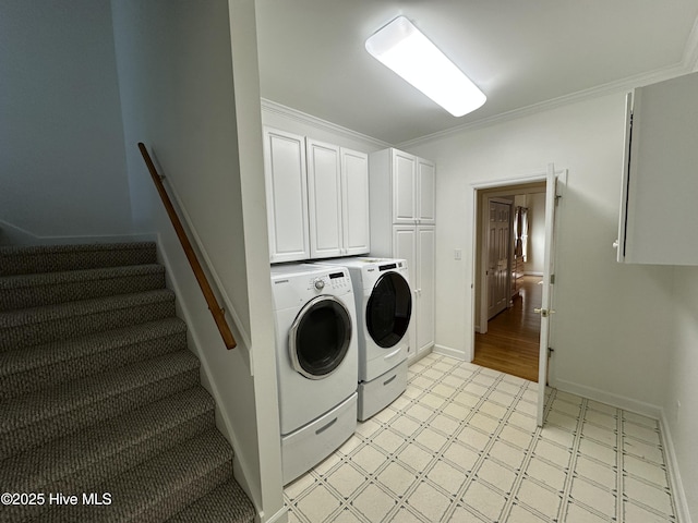 clothes washing area with baseboards, washer and dryer, cabinet space, light floors, and crown molding