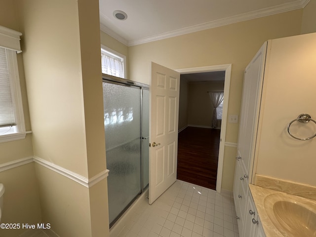 bathroom featuring ornamental molding, tile patterned flooring, a shower stall, and vanity