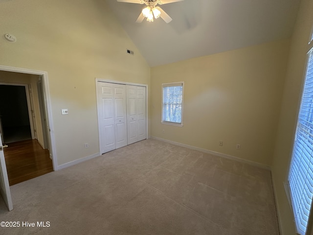 unfurnished bedroom with high vaulted ceiling, carpet, visible vents, and baseboards