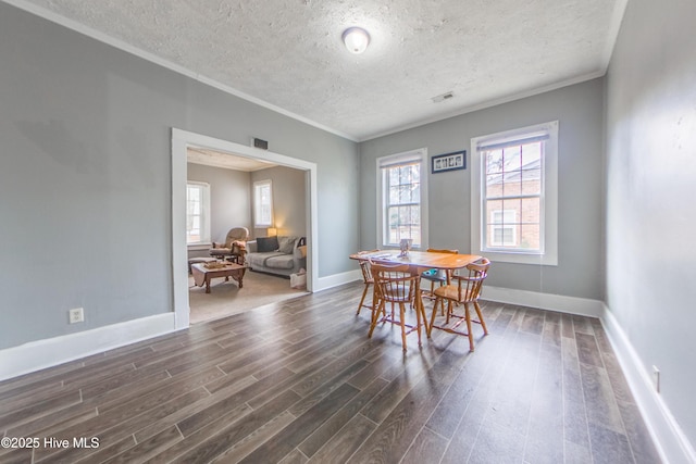 dining room featuring dark hardwood / wood-style flooring, a textured ceiling, and crown molding