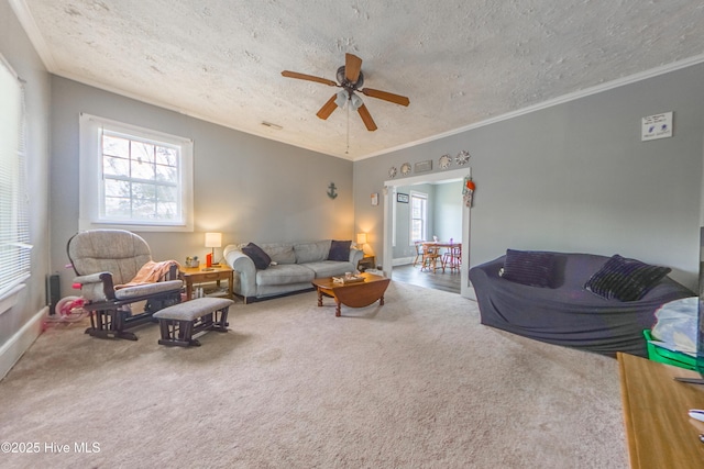 carpeted living room with a textured ceiling, ceiling fan, ornamental molding, and a wealth of natural light