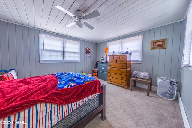 carpeted bedroom with ceiling fan and wooden walls