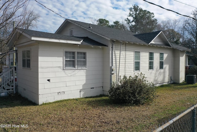 view of side of home with central air condition unit and a lawn