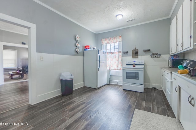 kitchen featuring white appliances, dark hardwood / wood-style floors, white cabinets, and a textured ceiling