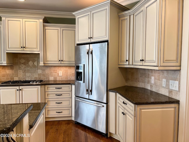 kitchen featuring dark stone countertops, cream cabinets, and stainless steel appliances