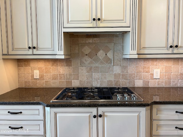 kitchen with tasteful backsplash, white cabinets, and stainless steel gas cooktop