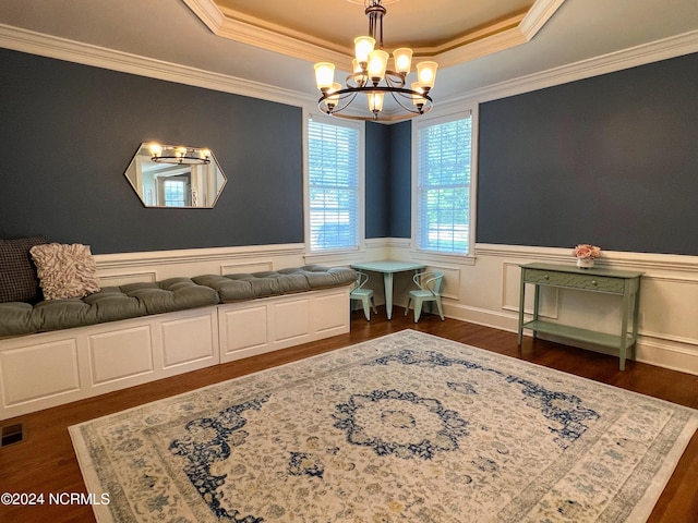 living area featuring an inviting chandelier, dark hardwood / wood-style flooring, crown molding, and a tray ceiling