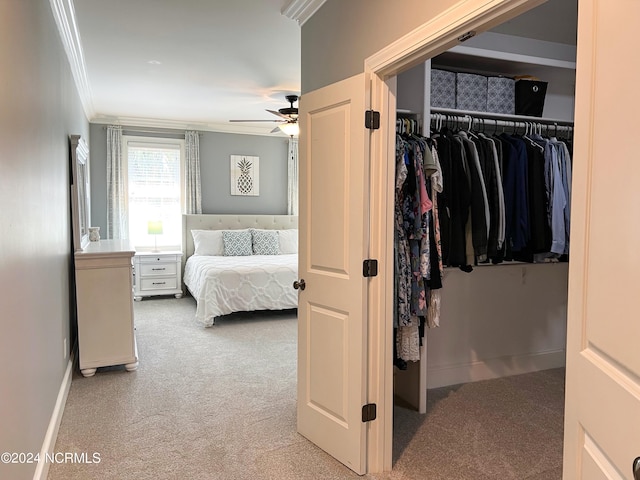 bedroom featuring a closet, ceiling fan, crown molding, and light colored carpet