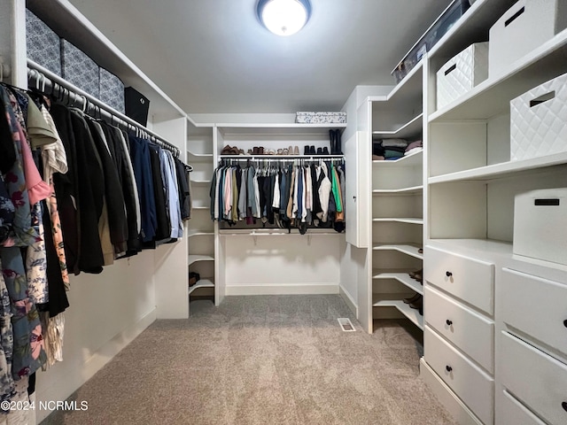 walk in closet featuring light carpet