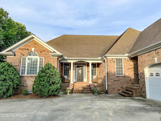 view of front of property featuring covered porch and a garage