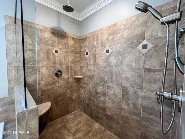 bathroom with a tile shower and ornamental molding