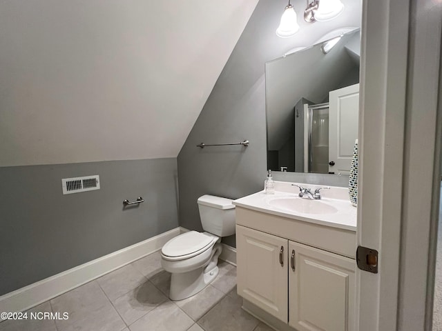 bathroom with vanity, lofted ceiling, a shower with door, tile patterned floors, and toilet