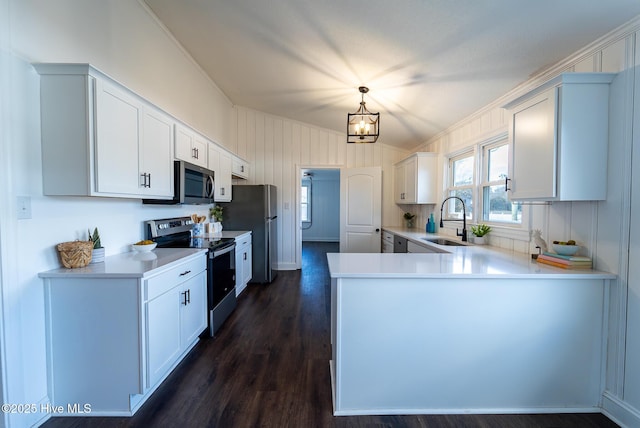 kitchen with hanging light fixtures, white cabinets, appliances with stainless steel finishes, and sink