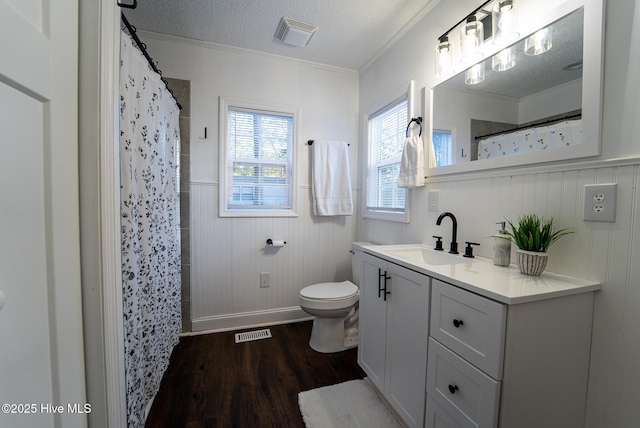 bathroom featuring toilet, wood-type flooring, a textured ceiling, crown molding, and vanity