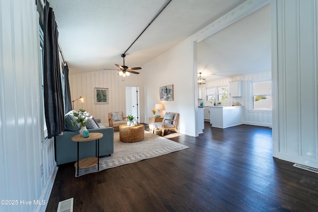 living room featuring ceiling fan, dark hardwood / wood-style flooring, lofted ceiling, and sink